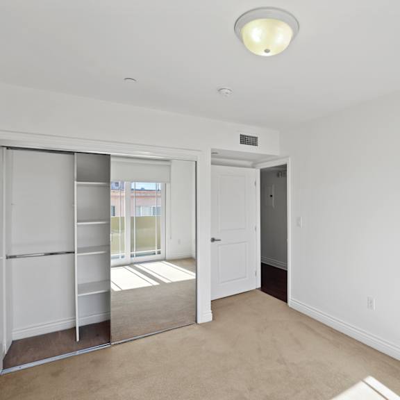 bedroom with mirrored closet with shelving