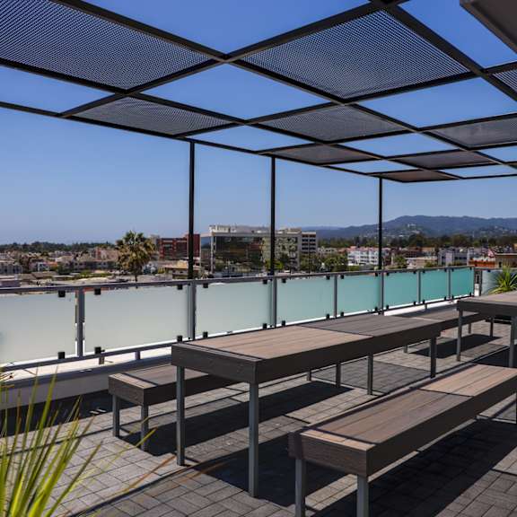 a deck with benches and tables overlooking a body of water