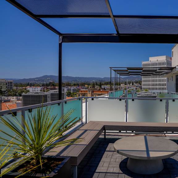 a roof terrace with a table and a view of the city