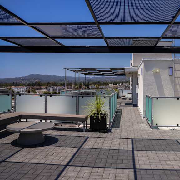 a roof terrace with a view of a city and a blue sky