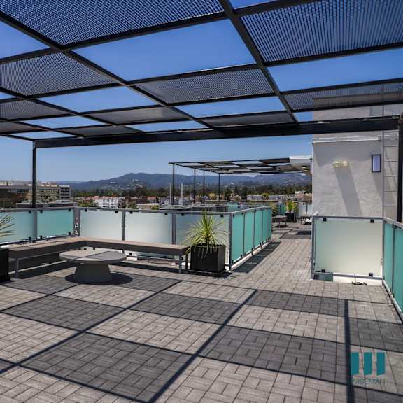 a roof terrace with tables and chairs and a view of a city and a
