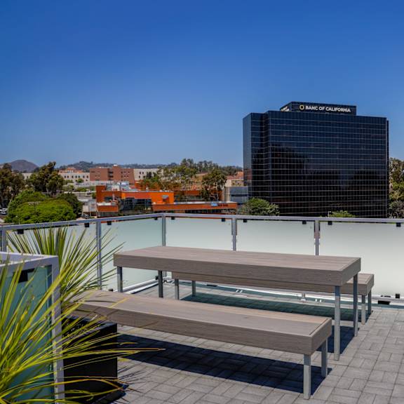 a roof deck with two benches and a view of the city