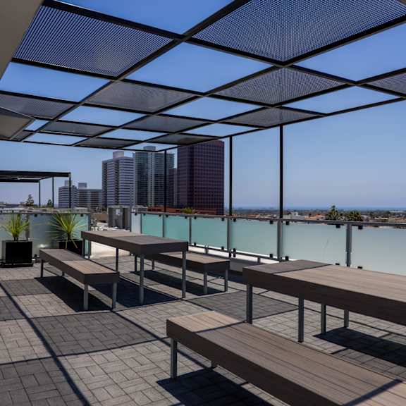 a deck with benches and tables overlooking a body of water and buildings