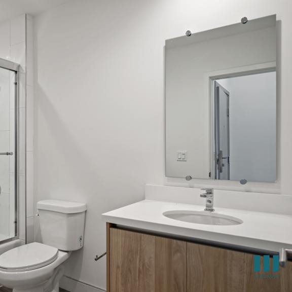 a white bathroom with a shower sink and toilet
