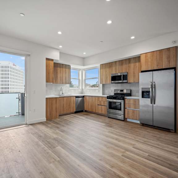 a large kitchen with stainless steel appliances and a city view