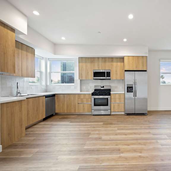 a kitchen with a geometric design on the wall and wood floors
