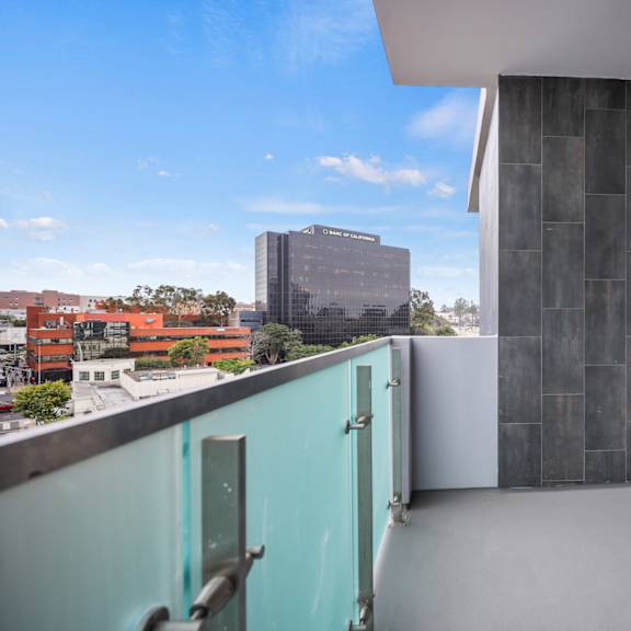 a balcony with a door and a city in the background