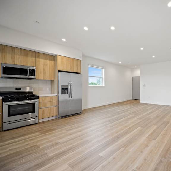 a kitchen and living room with wood floors and white walls