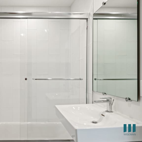 a white bathroom with a shower and a sink