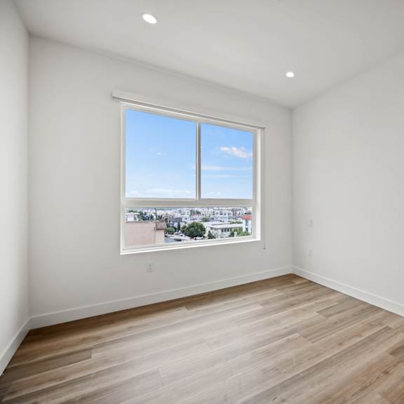 a living room with white walls and a window