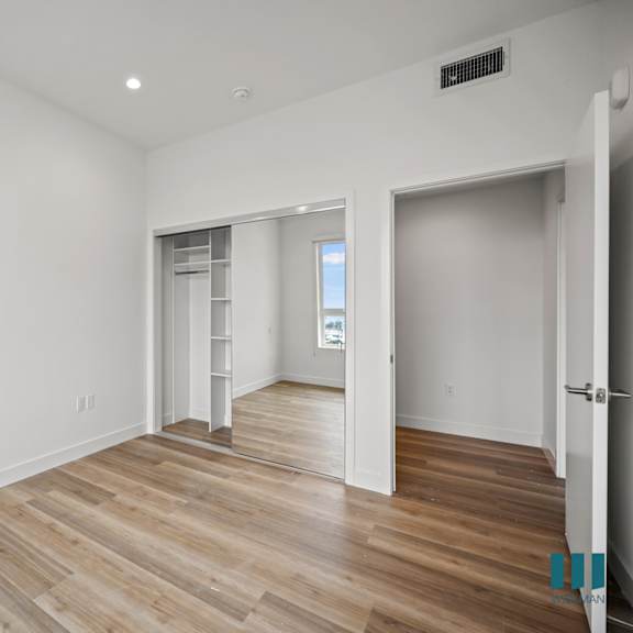 a living room with white walls and wood flooring