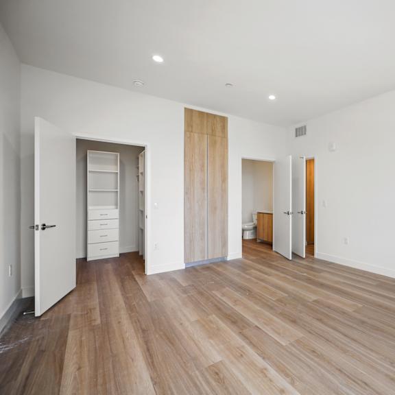 a renovated living room with white walls and wood floors