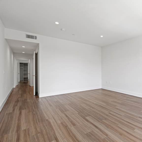 large-size bedroom with walk-in closet with built-in shelving, recessed lighting, and vinyl flooring