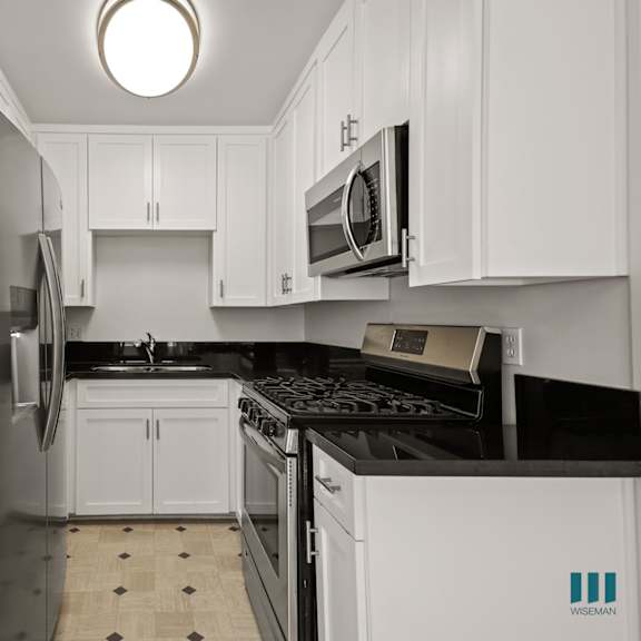 kitchen with stainless-steel refrigerator, stove, microwave oven, and ample cabinet storage