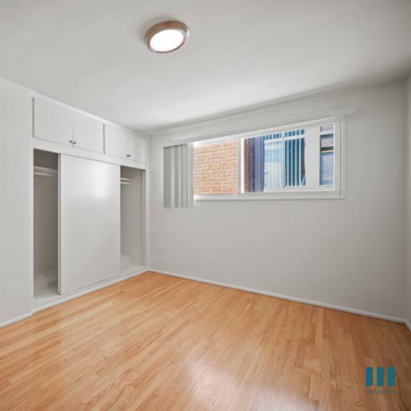 bedroom with closet, cabinet storage, and hardwood flooring