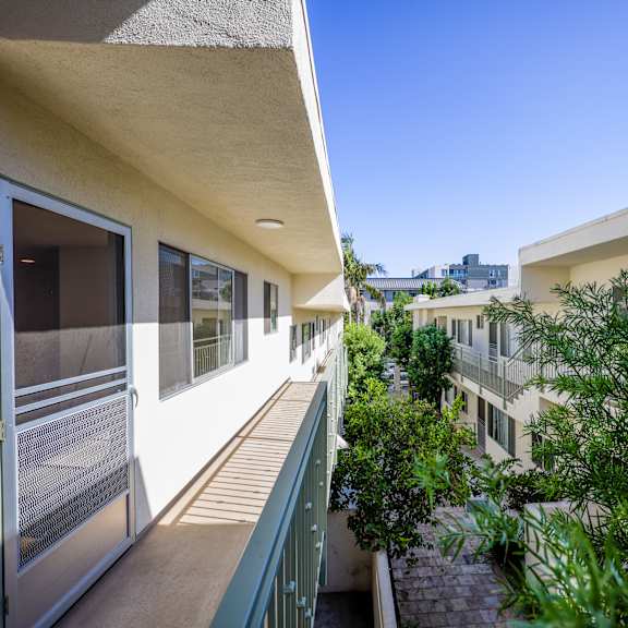 a balcony with a view of a building and some trees