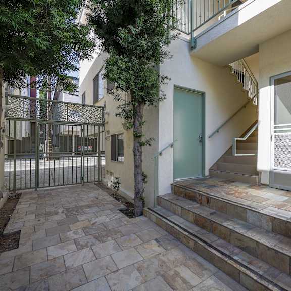 the front door of a house with stairs and a courtyard