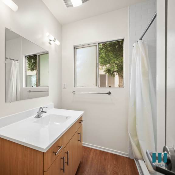 a bathroom with a sink and a mirror and a shower