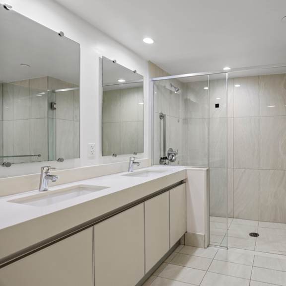 bathroom with a full-size bathtub, shower, and double-sink vanity