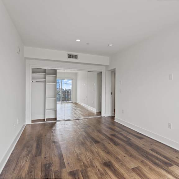 bedroom with large-size mirrored closet with shelving