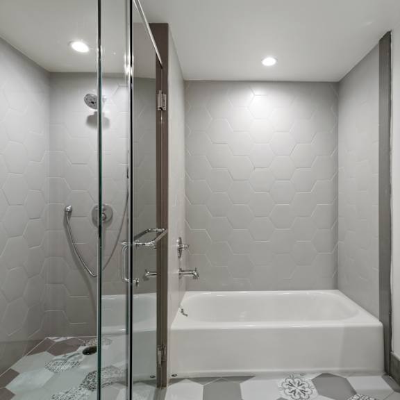 bathroom with bathtub and walk-in shower with glass door