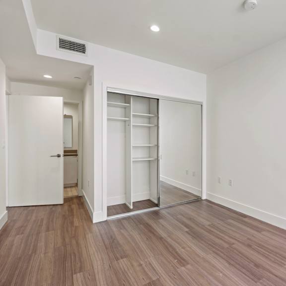 bedroom with mirrored closet with shelving
