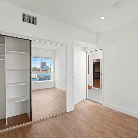 bedroom with mirrored closet with shelving