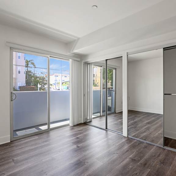 bedroom with two mirrored closets and balcony