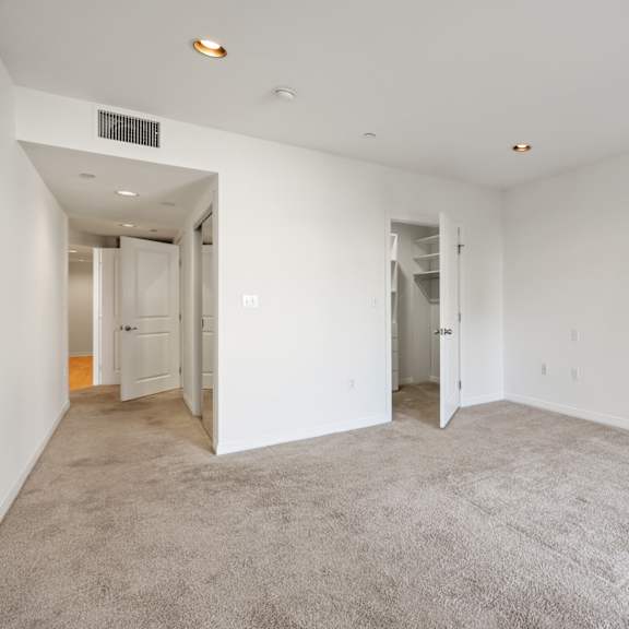 bedroom withwalk-in closet, carpet, and recessed lighting