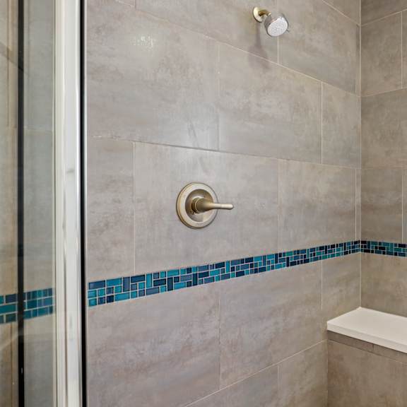 walk-in shower with glass shower door and interior bench