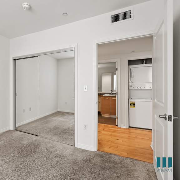 bedroom with mirrored closet and in-suite washer & dryer