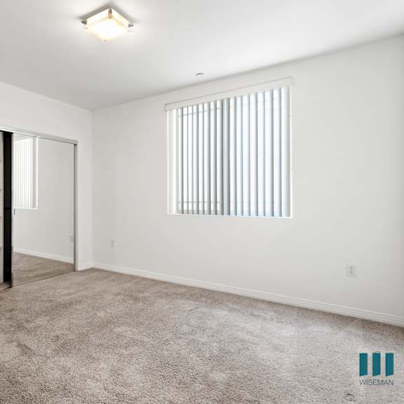 bedroom with closet with shelving, carpet, and window