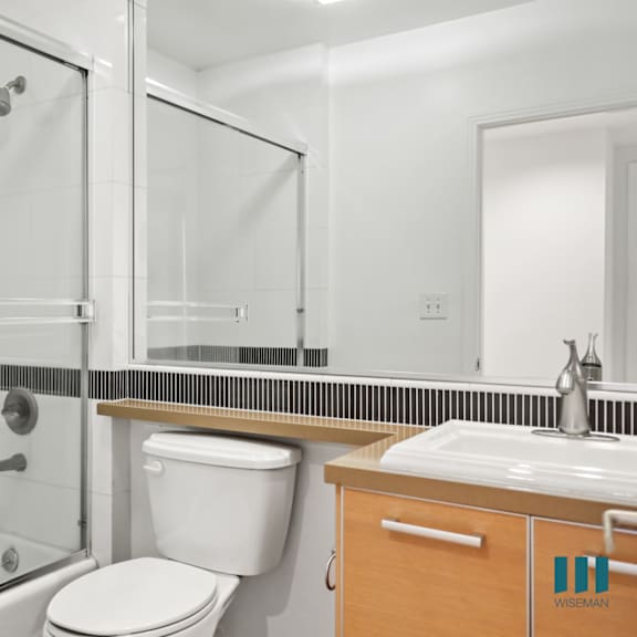 bathroom with shower bath with glass door and vanity cabinet storage