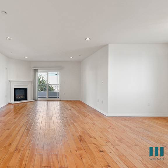 open-concept dining and living room areas with electric fireplace, vinyl flooring, and patio