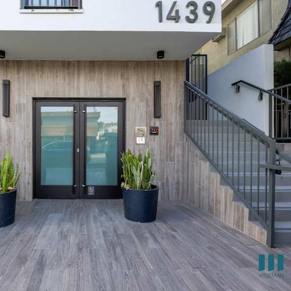an entrance to a building with a glass door and potted plants