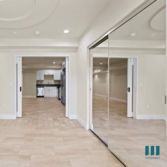 bedroom entrance with view of the living room and kitchen