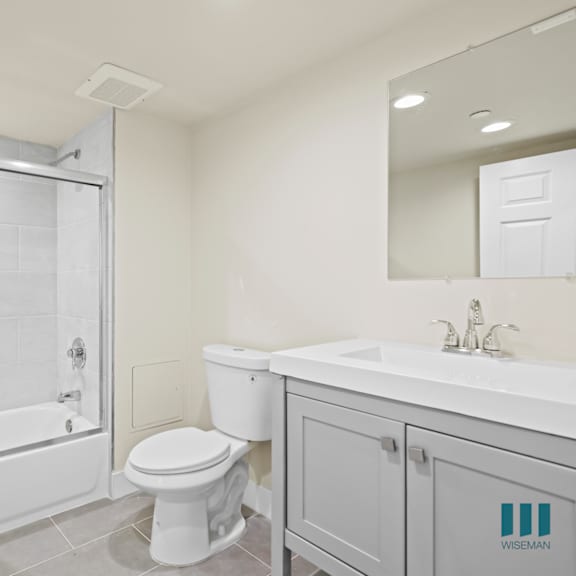 bathroom with shower-bath with glass door and vanity cabinet storage