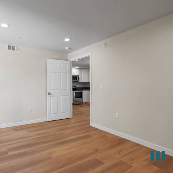 bedroom with vinyl flooring and large windows