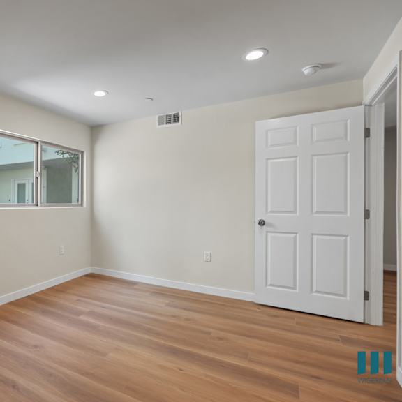 bedroom with recessed lighting, vinyl flooring, and window