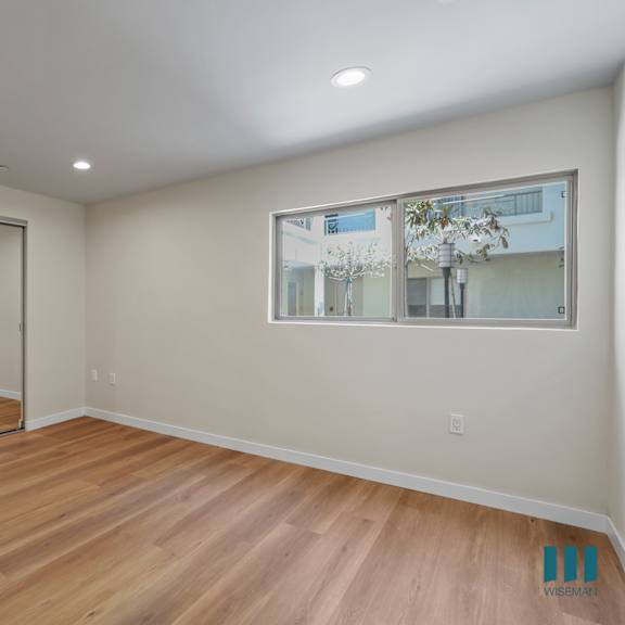bedroom with mirrored closet, large-size windows, and recessed lighting