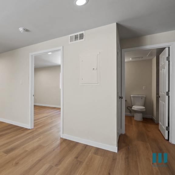 bedroom with recesseed lighting, vinyl flooring, and bathroom