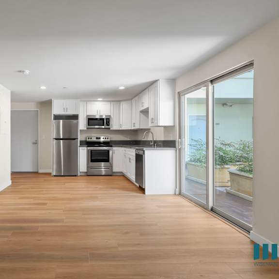 open-concept kitchen, dining, and living room area with patio