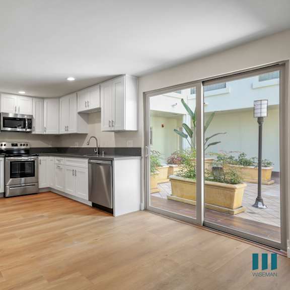open-concept kitchen with stainless-steel refrigerator, stove, microwave oven, and dishwasher