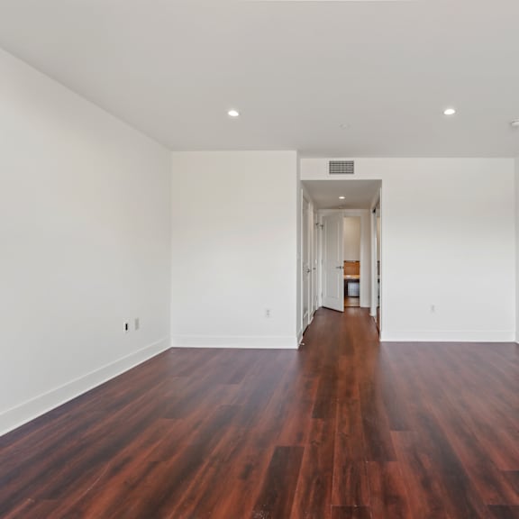 bedroom with recessed lighting, vinyl flooring, and walk-in closets