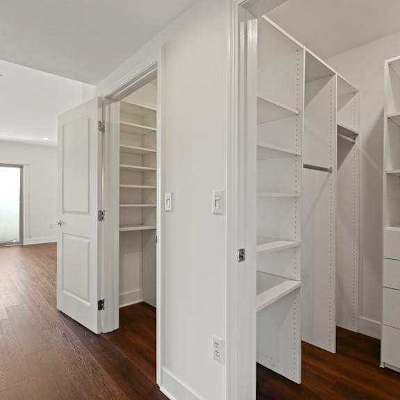 bedroom with double walk-in closets, vinyl flooring, and patio