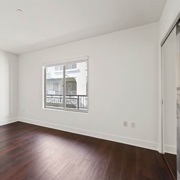 bedroom with mirrored closet, vinyl flooring, and windows