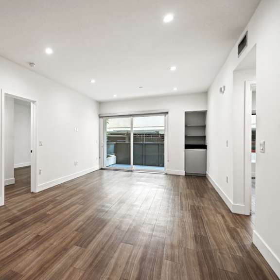 living room with built-in storage, patio, and vinyl flooring