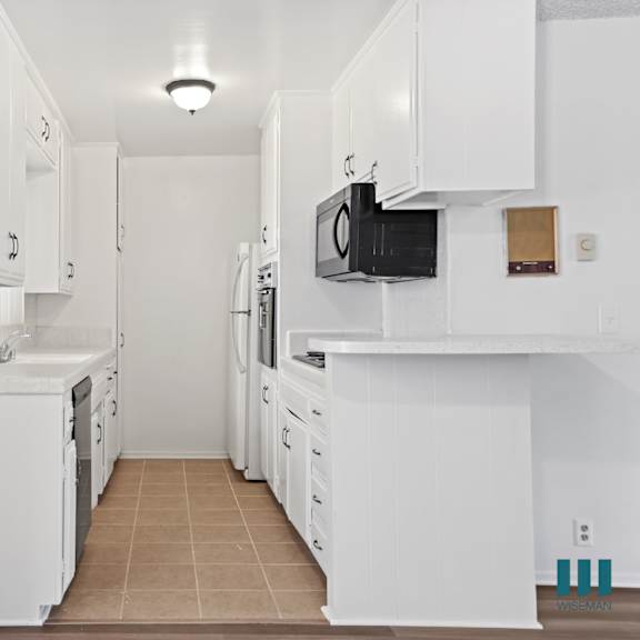a kitchen with white cabinets and appliances.