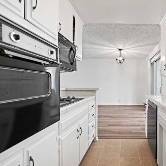 a kitchen with white cabinets and a black stove top oven.