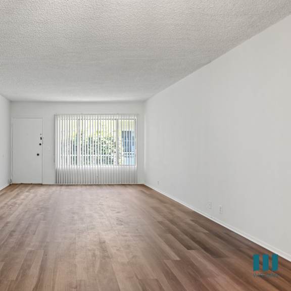 a room with wooden floors and white walls.